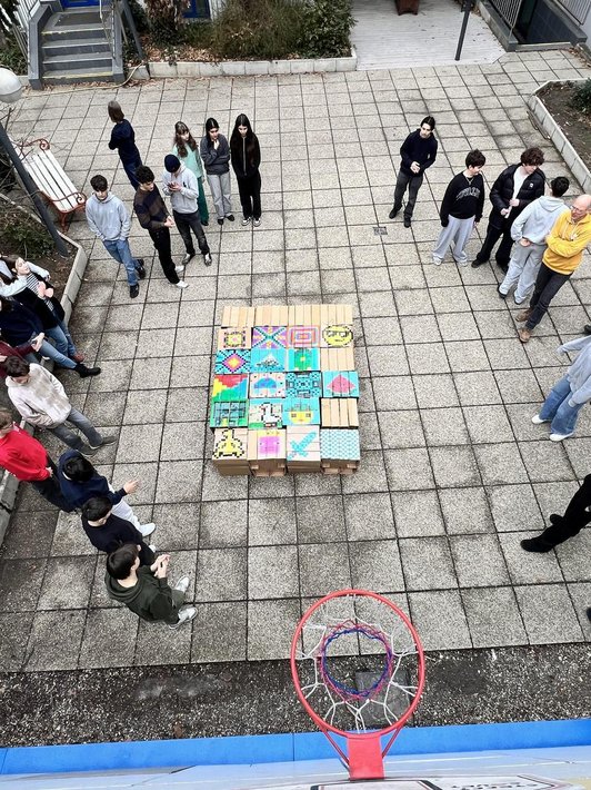 Foto der fertigen bunten Hocker aus Karton zusammengestellt mit Schüler:innen rundherum von oben.