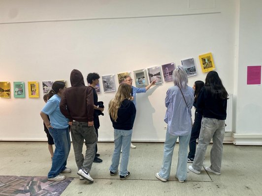 Jugendliche bei Führung vor Reihe von Foto-Kunstwerken