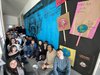 Foto von Schülerinnen und Schülern sitzend in einem Gang vor ihrem Plakt in blau schwarz. Schriftzug Climate change is real Bild: Einstein mit Taucherbrille unter Wasser