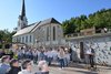 Kindergruppe mit einem Redner stehen vor einem Denkmal