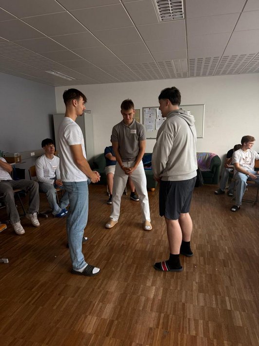 Drei Jugendliche stehen Mitten im Raum und ballen die Fäuste.