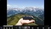 Screenshot einer Videokonferenz, auf dem geteilten Bildschirm ist eine Hand mit dem Modell einer Landschaft vor einem Landschaftsfoto zu sehen.