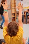 Foto eines Schülers mit erhobenen Armen von hinten