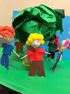 Gebastelte Figuren vor einem Baum aus Papier