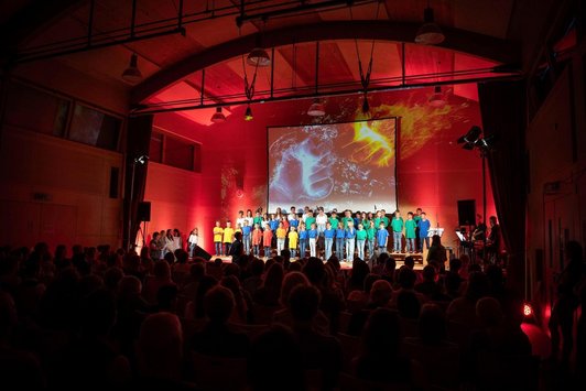 Blick in die Abschlussszene mit vielen Kindern und Videoprjektion