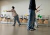 Drei Schüler hantieren mit Sticks in der Luft