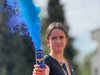 Foto einer Schülerin die einen Energydrink mit dem Zeichen der Europäischen Union hält, aus dem blauer Rauch aufsteigt
