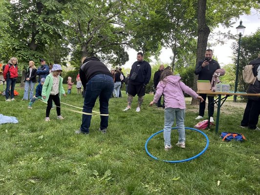 Kinder und Erwachsene beim Spielen im Grünen
